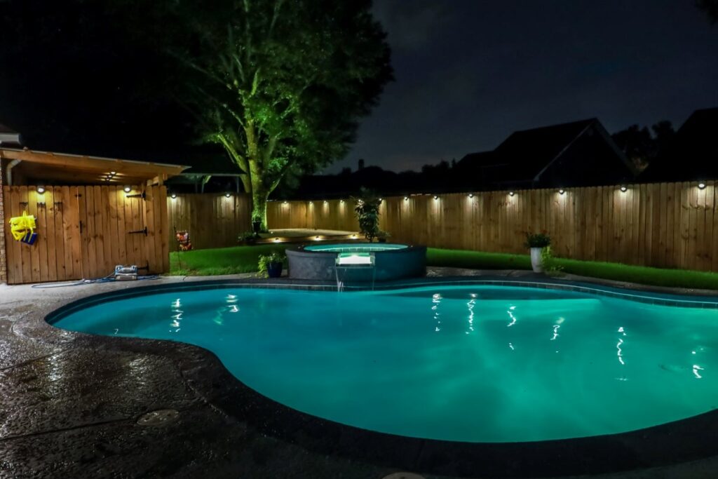 Melhorando a privacidade em seu quintal com paisagismo de piscina com iluminação adequada
